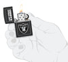 NFL Las Vegas Raiders Windproof Lighter lit in hand.
