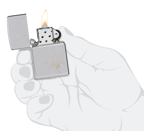 Zippo Spider Web Design High Polish Chrome Windproof Lighter lit in hand.