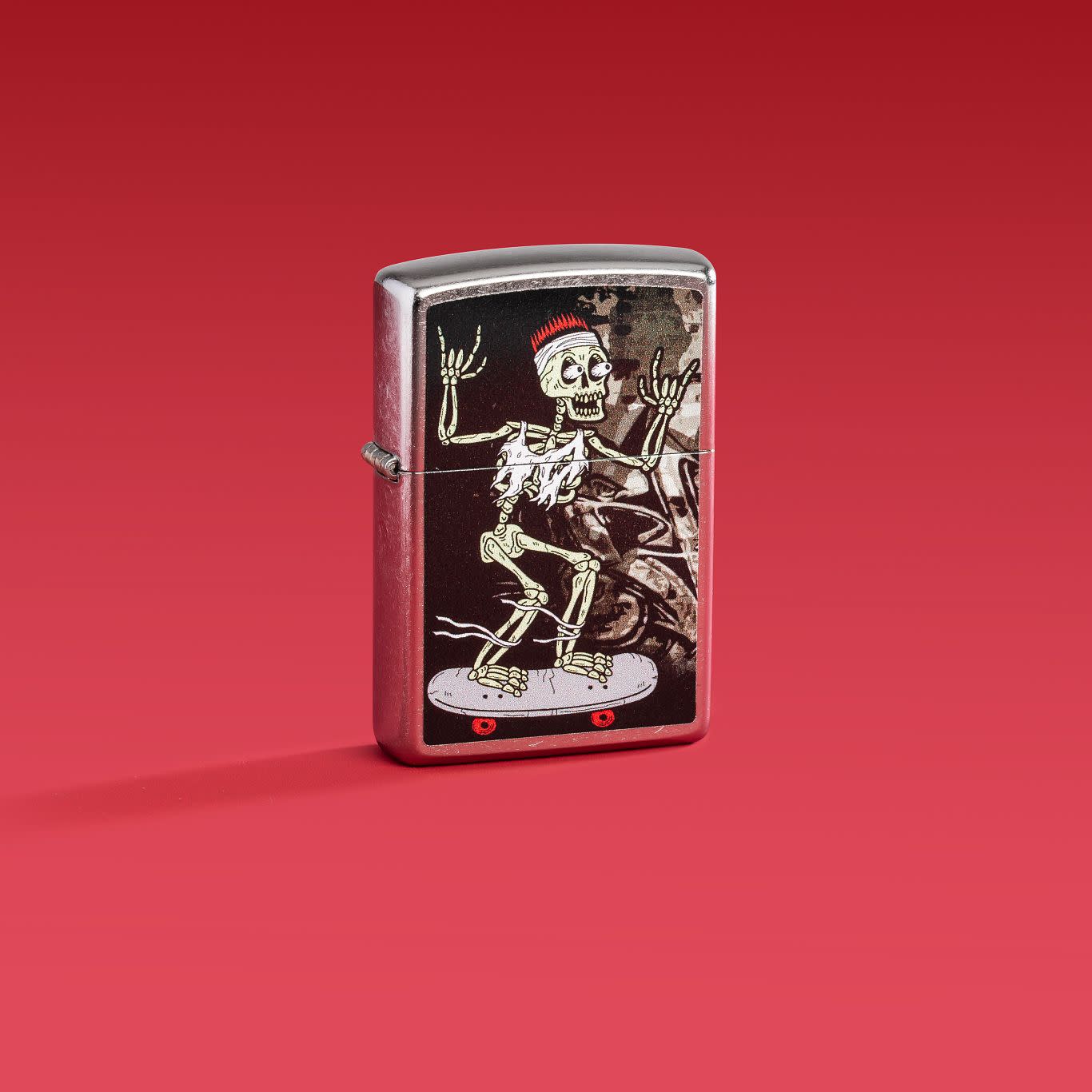 Lifestyle image of Zippo Skateboard Street Chrome Windproof Lighter on a red background.