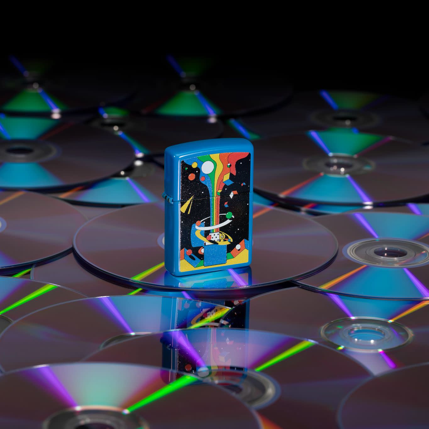 Lifestyle image of Zippo Cosmic Zippo Design Sky Blue Matte Windproof Lighter standing on a bunch of CDs.