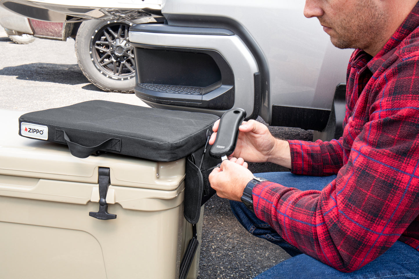 Lifestyle image of Zippo Heated Seat - Single, with a man plugging in HeatBank® 9s (not included)