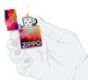 Zippo Tie Dye Design 540 Tumbled Chrome Windproof Lighter lit in hand.