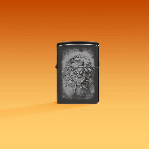 Lifestyle image of Zippo Clown High Polish Black Windproof Lighter on an orange ombre background.