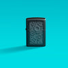 Lifestyle image of Zippo Steampunk Design Black Matte Windproof Lighter on a teal background.