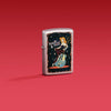 Lifestyle image of Zippo Cool Chick Design Satin Chrome Windproof Lighter on a red background.