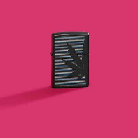 Lifestyle image of Zippo Cannabis Design Black Matte Windproof Lighter on a hot pink background.