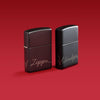 Lifestyle image of two Zippo Design Black Matte with Chrome Windproof Lighters on a red background.