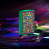 Lifestyle image of Zippo Trippy Design Grass Green Matte Windproof Lighter sitting on a stack of CDs.
