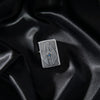 Lifestyle image of Anne Stokes Gothic Prayer Emblem Brushed Chrome Windproof Lighter laying in a black scene.