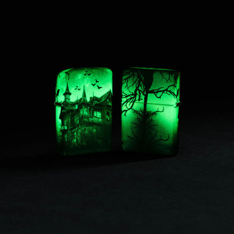 Lifestyle image of two Zippo Horror House Glow in the Dark Matte Windproof Lighters glowing in the dark.