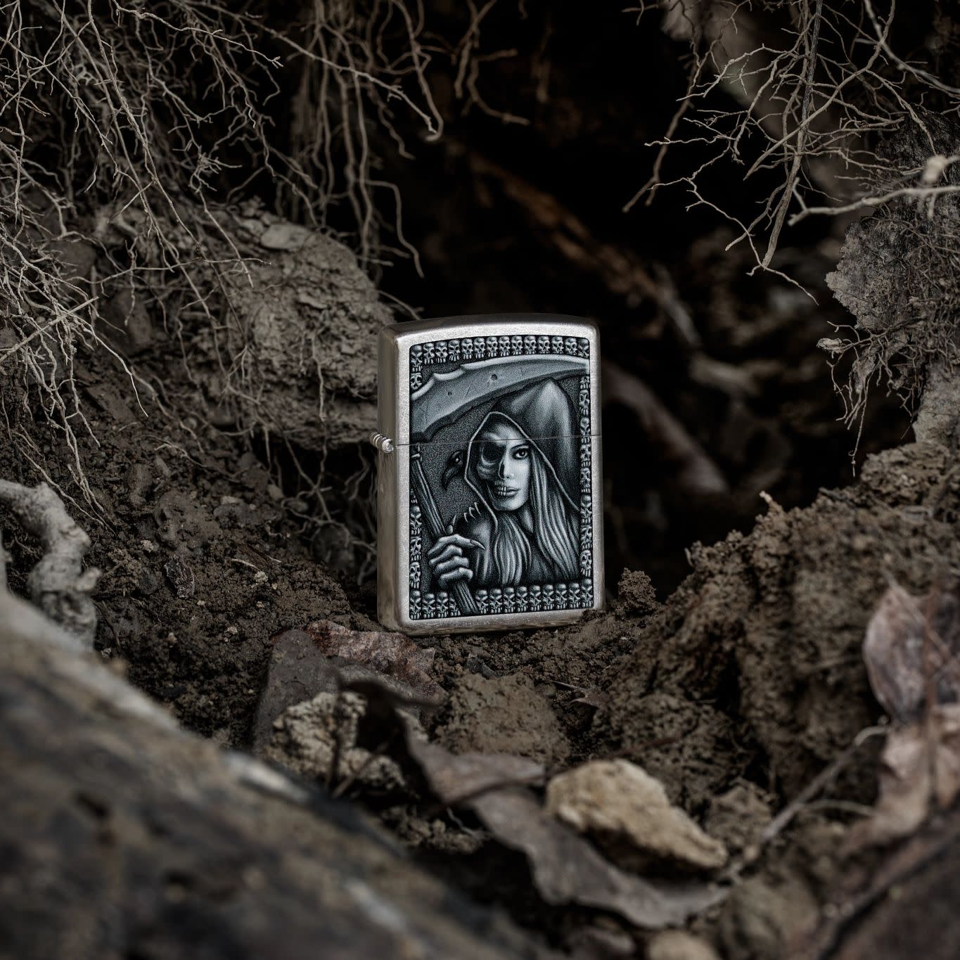 Lifestyle image of Zippo Grim Beauty Design Street Chrome Windproof Lighter standing in dirt.