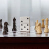 Lifestyle image of Zippo Domino Design White Matte Windproof Lighter standing on a chess board.