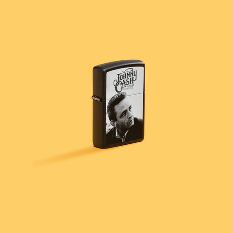 Lifestyle image of Zippo Johnny Cash Black Matte Windproof Lighter on a yellow background.