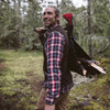 Lifestyle image of man in the woods carrying wood with the AxeSaw