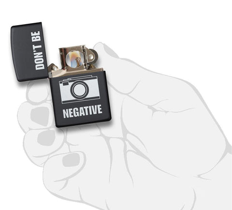 Front view of the Don't Be Negative Black Matte Windproof Lighter in hand, open and lit 