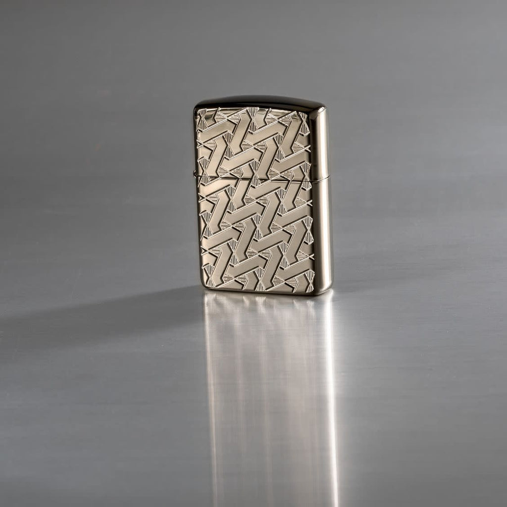 Lifestyle image of Armor Geometric Weave High Polish Black Ice Windproof Lighter standing on a reflective surface