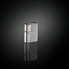 Lifestyle image of Armor® Sterling Silver Zippo Diamond Design Windproof Lighter standing in a black mirrored surface