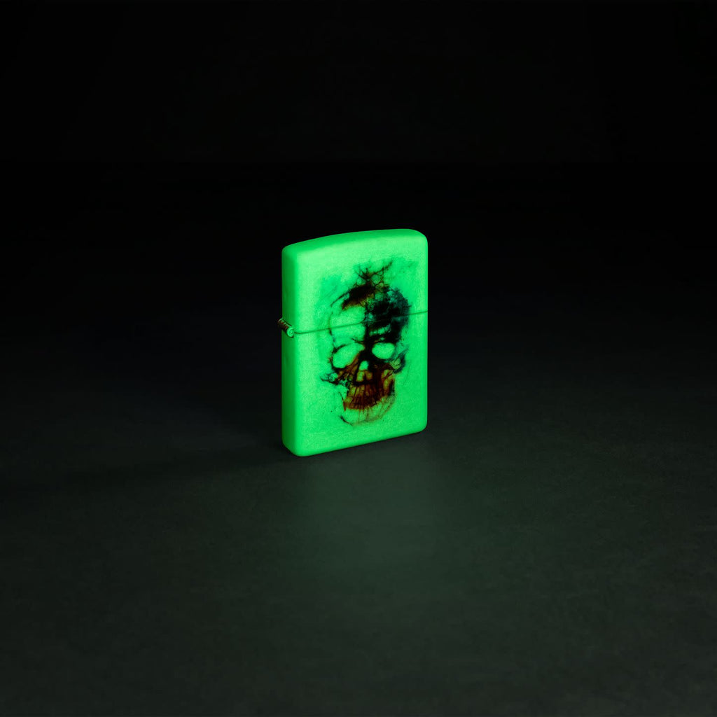 Glamour shot of Zippo Skull Print Design Glow in the Dark Matte Windproof Lighter glowing in the dark.