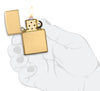 Armor® High Polish 18K Solid Gold Windproof Lighter lit in hand.