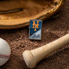 Lifestyle image of MLB® New York Mets™ Street Chrome™ Windproof Lighter laying on a baseball field with a glove, ball, and bat.
