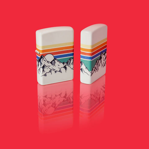 Glamour shot of two Zippo Mountain Design 540 Color Windproof Lighters standing in a red scene.