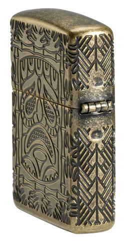 Tiki Design Armor® Antique Brass Windproof Lighter standing at an angle, showing the back and hinge side of the lighter.