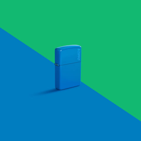 Glamour shot of Zippo Sky Blue Matte Zippo Logo Classic Windproof Lighter standing in a split green and blue scene.