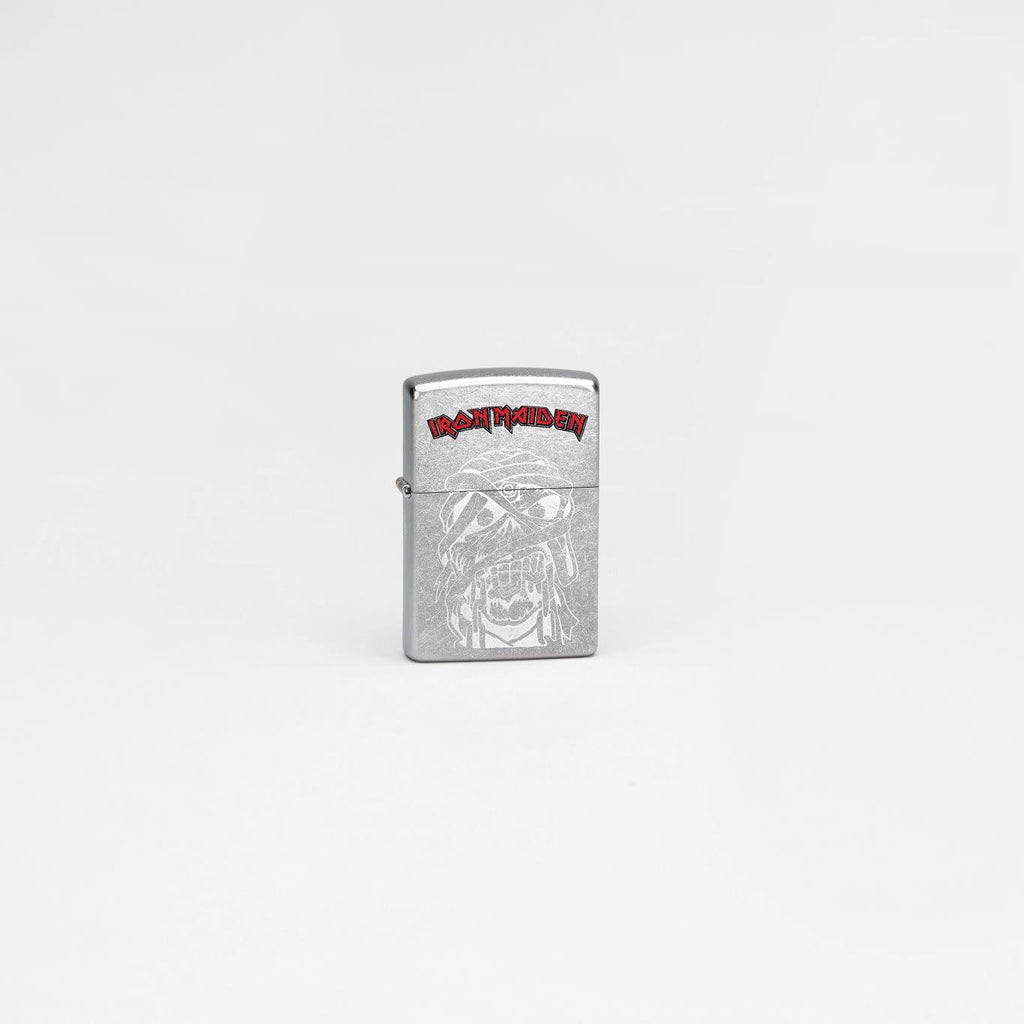 Lifestyle image of Zippo Iron Maiden Eddie Street Chrome Windproof Lighter in a grey scene.