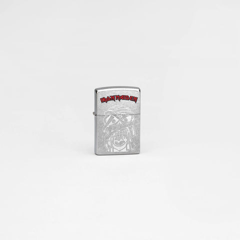 Lifestyle image of Zippo Iron Maiden Eddie Street Chrome Windproof Lighter in a grey scene.