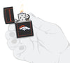 NFL Denver Broncos Windproof Lighter lit in hand.