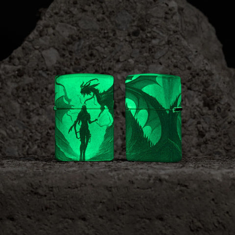 Lifestyle image of two Zippo Glowing Dragon Design 540 Color Glow in the Dark Windproof Lighters glowing in the dark.