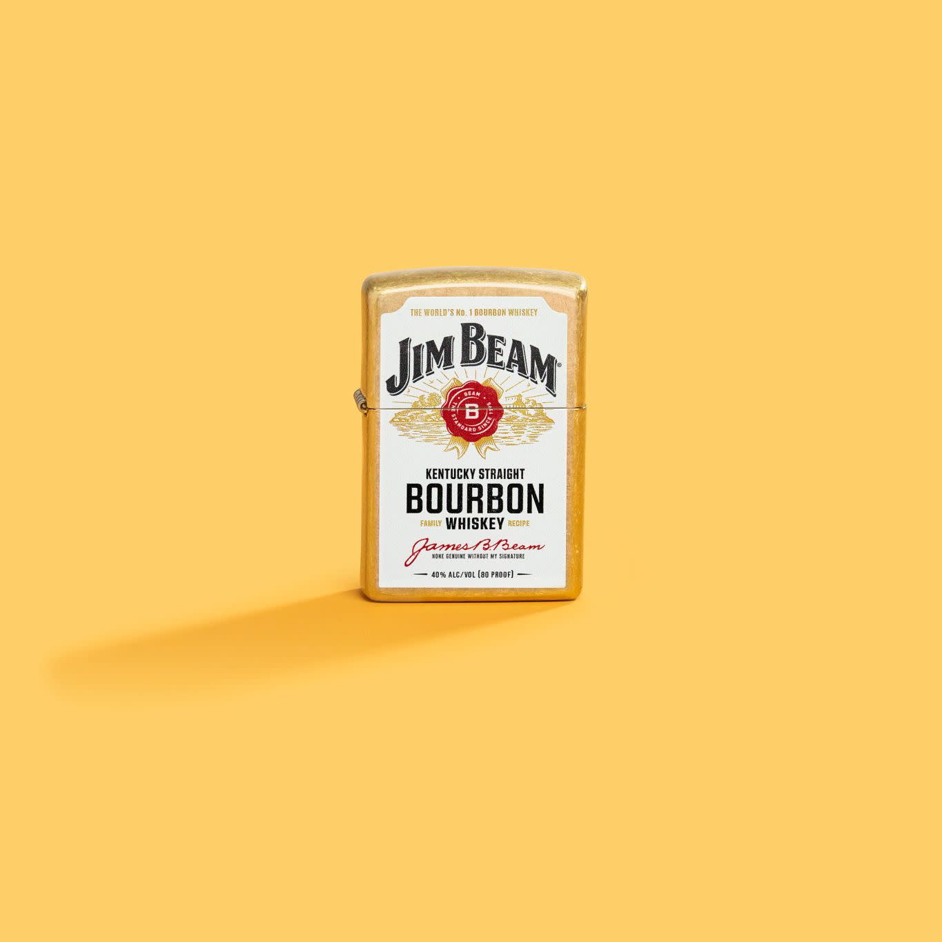Lifestyle image of Zippo Jim BeamÂ® Label Design Regular Street Brass Windproof Lighter standing with a sunny yellow background.