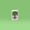 Lifestyle image of Zippo Tree Life Design White Matte Windproof Lighter standing in a green scene.