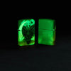 Lifestyle image of two Zippo Dragon Design Glow in the Dark Green Matte Windproof Lighters glowing in the dark.