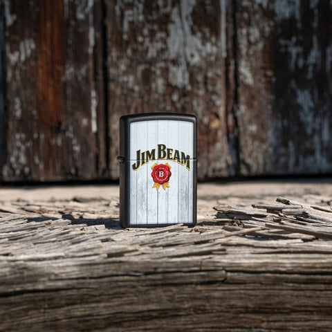 Lifestyle image of Zippo Jim Beam Black Matte Windproof Lighter stanind outside on a wooden table.