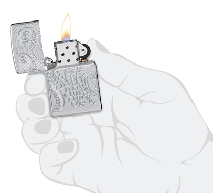 Zippo Tentacles Design ArmorÂ® High Polish Chrome Windproof Lighter lit in hand.