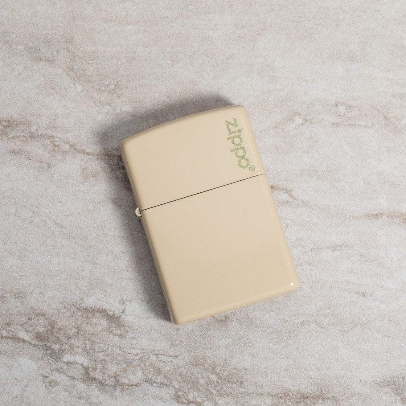Lifestyle image of Classic Flat Sand Zippo Logo laying on a marble surface