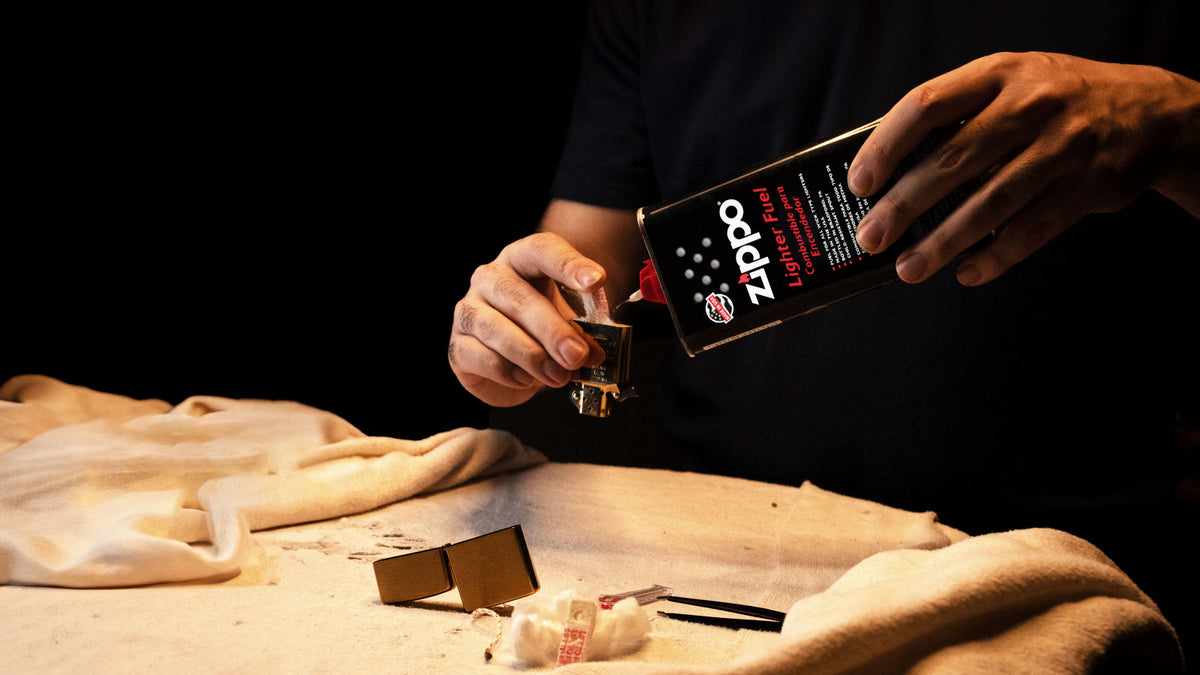 Man re-refueling a Zippo Lighter.
