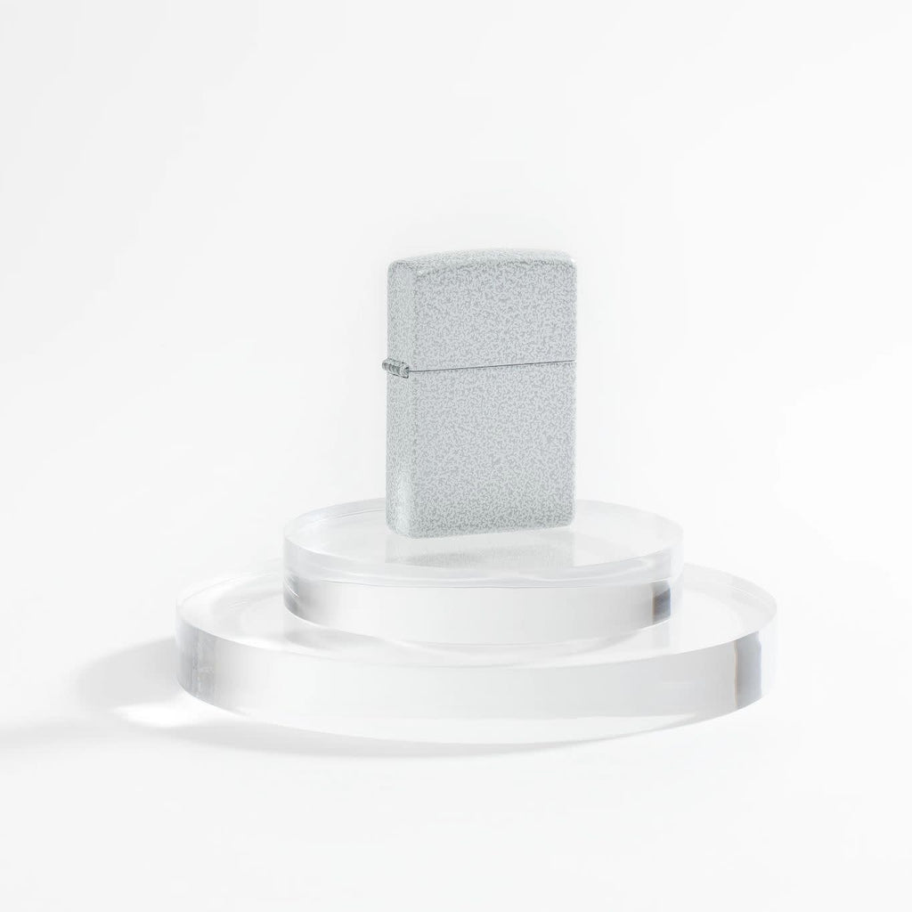 Lifestyle image of Zippo Classic Glacier Windproof Lighter on a clear pedestal and a white background.
