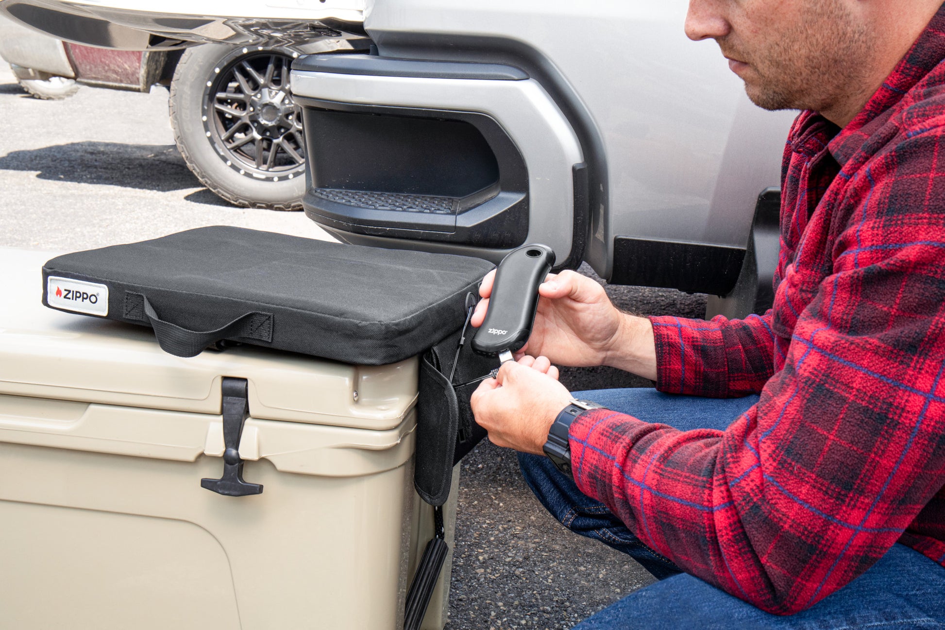 Lifestyle image of Zippo Heated Seat - Single, with a man plugging in HeatBank® 9s (not included)