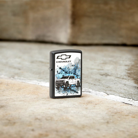 Lifestyle image of Zippo Chevrolet Black Matte Pocket Lighter standing on stone ground.