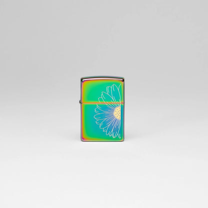 Lifestyle image of Zippo Daisy Design Multi Color Windproof Lighter standing in a grey scene.