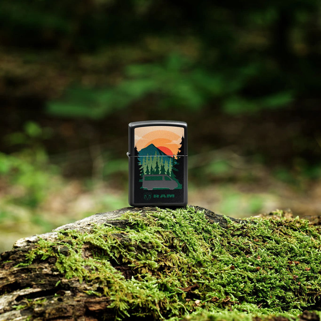Lifestyle image of Zippo RAM Black Matte Windproof Lighter standing outside on a mossy log.