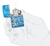 Zippo Atlantis Design High Polish Blue Windproof Lighter lit in hand.