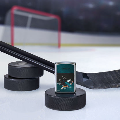 Lifestyle image of the NHL® San Jose Sharks™ Street Chrome™ Windproof Lighter standing with a hockey puck and hockey stick, with a hockey net in the background.