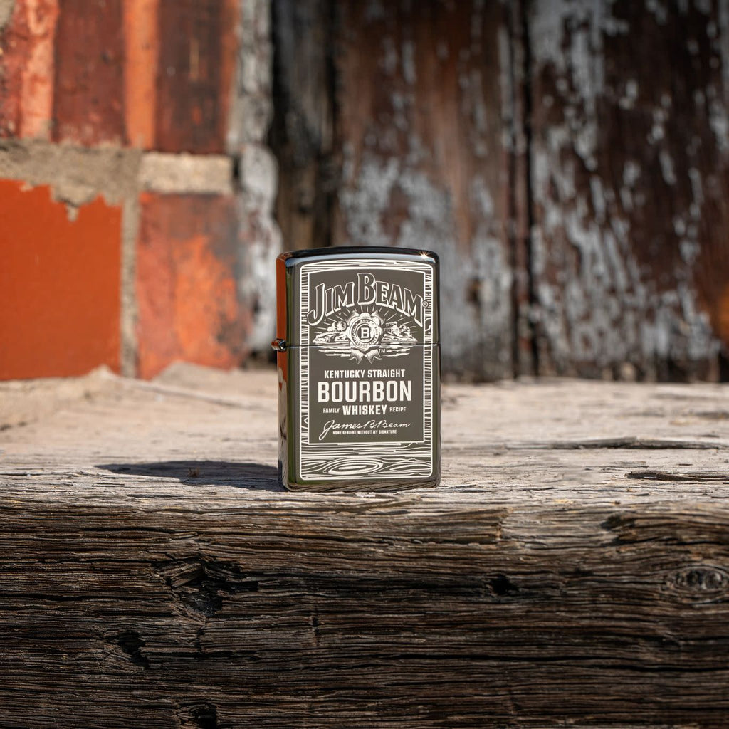 Lifestyle image of Zippo Jim Beam Black Ice Windproof Lighter standing on wood with a brick wall behind it.