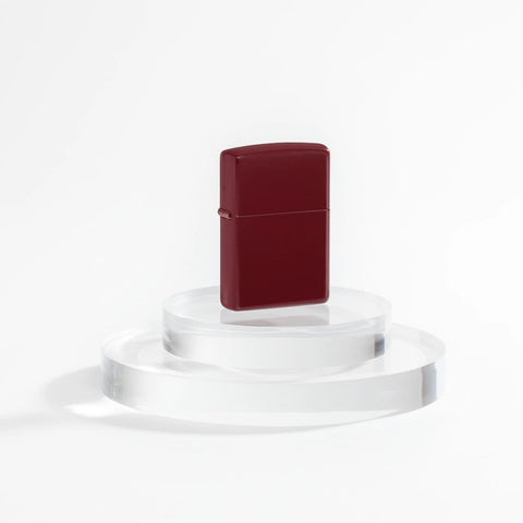 Lifestyle image of Zippo Classic Merlot Windproof Lighter on a clear pedestal with a white background.