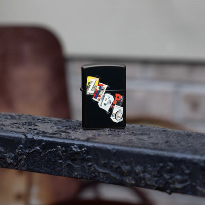 Lifestyle image of Zippo Cut and Paste Design Black Matte Windproof Lighter standing on a wrought iron fence.