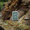 Lifestyle image of Zippo Jeep Street Chrome Windproof Lighter standing on a tree branch.