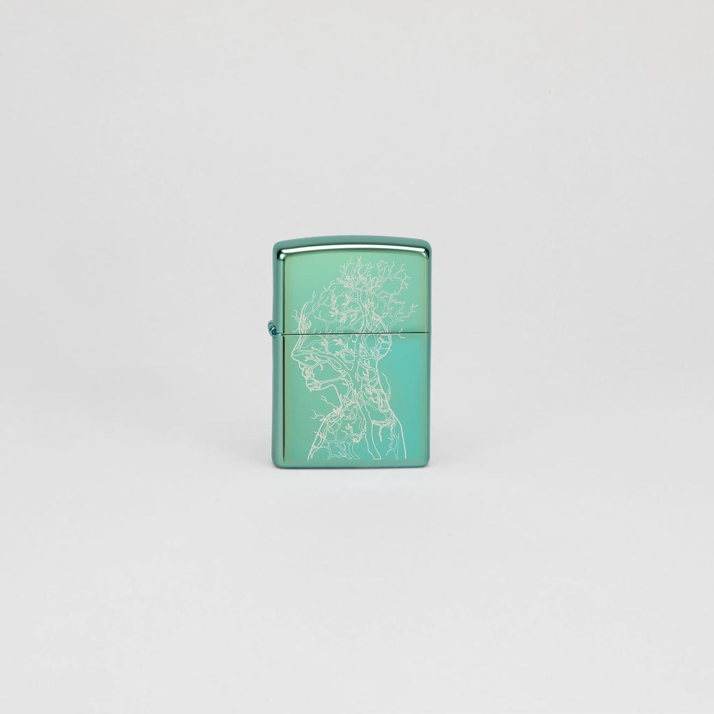 Lifestyle image of Zippo Human Tree Design High Polish Green Windproof Lighter standing in a grey scene.